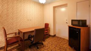 a room with a desk with a computer on top of it at Best Western Tulsa Airport in East Tulsa +10 photos