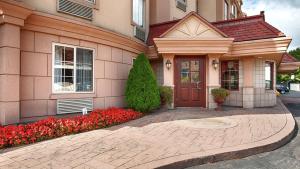 una casa con flores rojas delante de ella en Best Western On The Avenue en Buffalo