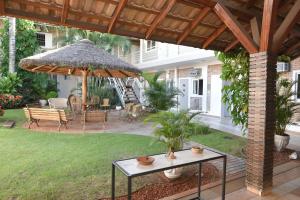 un patio con mesa y sombrilla en Hotel Pousada Mato Grosso, en Campo Grande