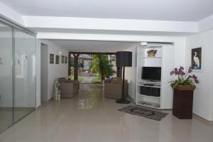 Hotel Pousada Mato Grosso في كامبو غراندي: غرفة معيشة مع أريكة وتلفزيون
