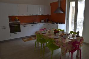 a kitchen with a table with green chairs and a table cloth at Casa Vacanza Comfort in Ceglie Messapica
