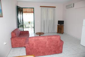 a living room with a red couch and a television at Villa Elena in Lixouri