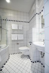 a white bathroom with a sink and a toilet at Hotel Garni Sunshine in Sölden