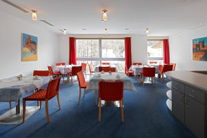 a dining room with tables and red chairs at Hotel Garni Sunshine in Sölden