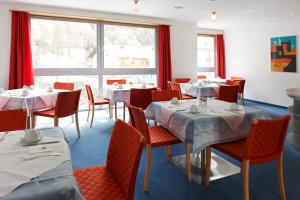 a dining room with tables and chairs and a window at Hotel Garni Sunshine in Sölden