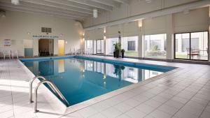Best Western North Bay Hotel & Conference Centre في نورث باي: مسبح كبير مع ماء ازرق في مبنى