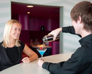 a man pouring a woman a drink in a martini glass at The Midland in Morecambe