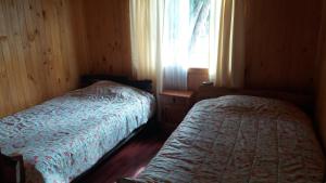 1 Schlafzimmer mit 2 Betten und einem Fenster in der Unterkunft Cabanas Neptuno in Quellón