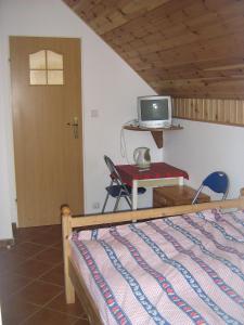 a bedroom with a bed and a desk and a tv at Cztery Wiatry in Jarosławiec