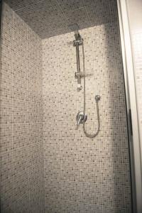 a shower in a bathroom with a tiled wall at Obelisco in Naples