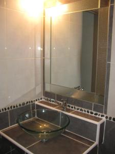 een badkamer met een wastafel en een grote spiegel bij Gite MARTIN in Grabels