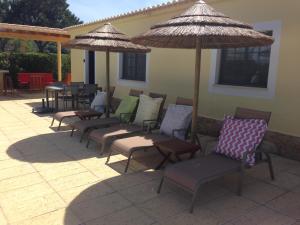 - un ensemble de chaises et de parasols sur une terrasse dans l'établissement Casa Paula Villas - Private Heated Pool for Each House, à Lagos