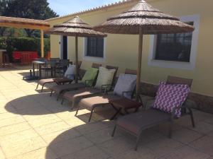 a group of chairs and umbrellas on a patio at Casa Paula Villas - Private Heated Pool for Each House in Lagos
