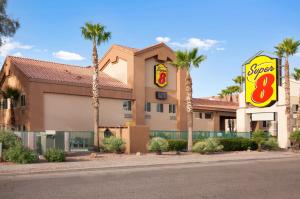 a shopping center with palm trees and a motel at Super 8 by Wyndham Marana/Tucson Area in Tucson