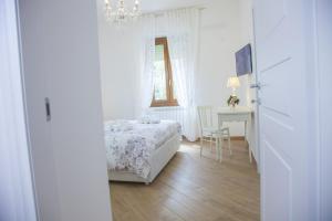 een slaapkamer met een bed, een tafel en een kroonluchter bij La Perla - Chic Accommodation in Sassari +24 foto's