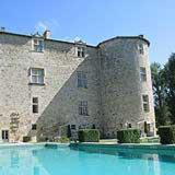 a large castle with a swimming pool in front of it at Château de Fourcès in Fourcès