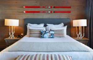 ein Schlafzimmer mit einem Bett mit zwei Lampen und Kissen in der Unterkunft Chalet-Hôtel La Mainaz Restaurant & Resort in Gex