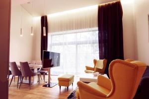 un soggiorno con tavolo, sedie e televisione di Villa Comfort a Palanga