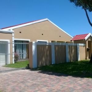 a house with a wooden fence in front of it at Zufike Self Catering in Port Elizabeth