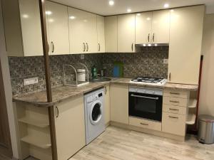 ブダペストにあるGoldcentral Apartment Gozsduのキッチン(白いキャビネット、洗濯機、乾燥機付)