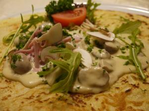 a plate of food with mushrooms and a tomato at Hotel Engel in Endingen