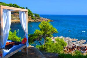 a bed with a view of the ocean with umbrellas at Apartments Lungo Mare Ulcinj in Ulcinj