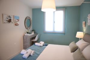 Habitación azul con cama y espejo en Dionisos Elia, en Paralia Dionisiou