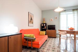 マリーナ・ディ・ラグーザにあるsiciliacasevacanze - Casa Maiolicaのリビングルーム(オレンジ色のソファ、テーブル付)