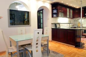 cocina con mesa, sillas y barra en Belgrade Republic Square Apartment, en Belgrado