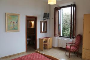 a room with a window and a table and a chair at Hotel La Marinella in Castiglioncello