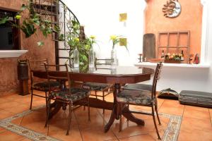 a dining room with a table with chairs and plants at Hotel Villa Florencia Centro Histórico in San Salvador