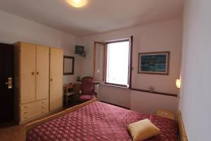 a bedroom with a bed and a window and a desk at Hotel La Marinella in Castiglioncello