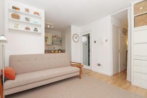 Una sala de estar con un sofá y un reloj en la pared. en City Centre Haven Apartments, en Edimburgo