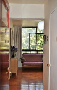 a living room with a couch and a large window at Santo Domingo frente Bellas Artes in Santiago