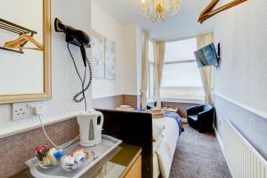 a room with a bed and a desk and a window at New Brooklyn in Blackpool