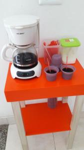 a mixer sitting on a red table with cups at Hotel Comercial Neiva in Neiva