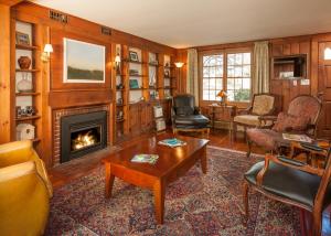 a living room with a fireplace and a table at Dragonfly Guest House in Ogunquit