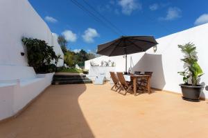 a patio with a table and an umbrella at Casa do Campo - A Minha Casa in Capelas