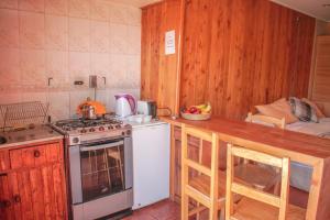 a kitchen with a stove and a counter with a sink at Cabañas Palafitos Los Pescadores in Castro