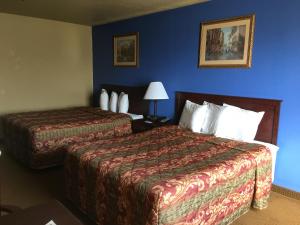 Cette chambre d'hôtel dispose de 2 lits et d'un mur bleu. dans l'établissement Econo Lodge Inn & Suites, à Greenbrier