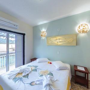 a bedroom with a bed with flowers on it at Pousada Casa de Pedra in Boicucanga