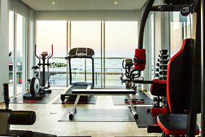 un gimnasio con equipo cardiovascular y una gran ventana en Karin hotel & Service apartment - SHA Extra Plus en Si Racha