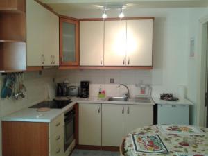 eine kleine Küche mit weißen Schränken und einem Waschbecken in der Unterkunft Patra - Cute studio near center in Patras