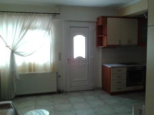 uma cozinha com uma porta branca e uma janela em Patra - Cute studio near center em Patra