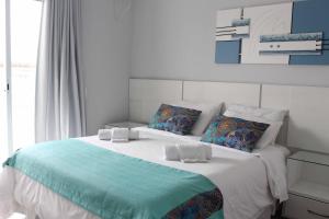 a bedroom with a large white bed with pillows at Hotel Pousada da Néia in Cananéia