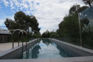 a swimming pool with a fence around it at Butterworth Cottage in Castlemaine