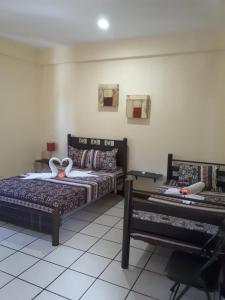 プラヤ・デル・カルメンにあるAlme Hostel Centro Playa del Carmenのベッドルーム1室(ベッド2台、ベンチ付)