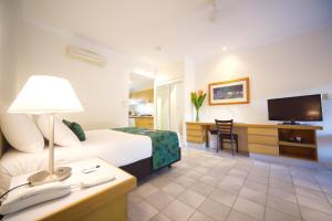 Habitación de hotel con cama y TV en Lazy Lizard Motor Inn, en Port Douglas