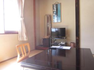 a dining room with a table and a television at Shiunso in Nikko