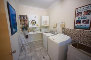 bagno con lavatrice, asciugatrice e lavandino di Lazy Lizard Motor Inn a Port Douglas